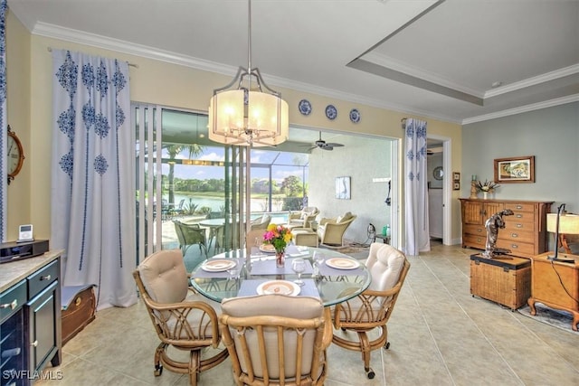 tiled dining space featuring crown molding, an inviting chandelier, and a tray ceiling