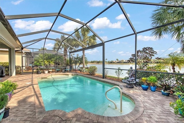 view of swimming pool featuring glass enclosure, a patio area, and a water view