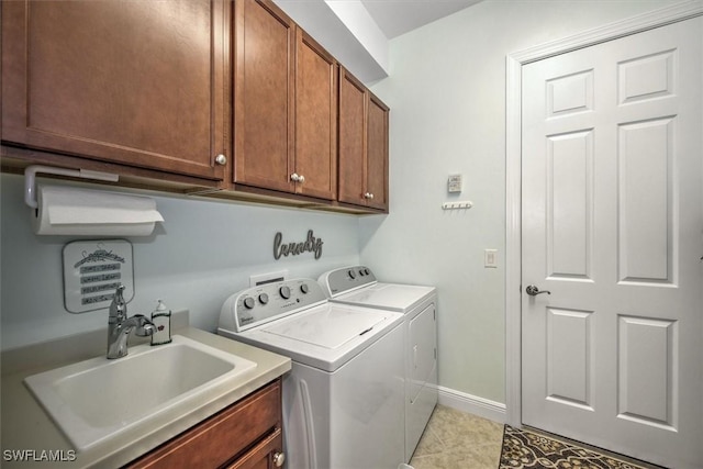 laundry room with sink, cabinets, washer and dryer, and light tile patterned floors