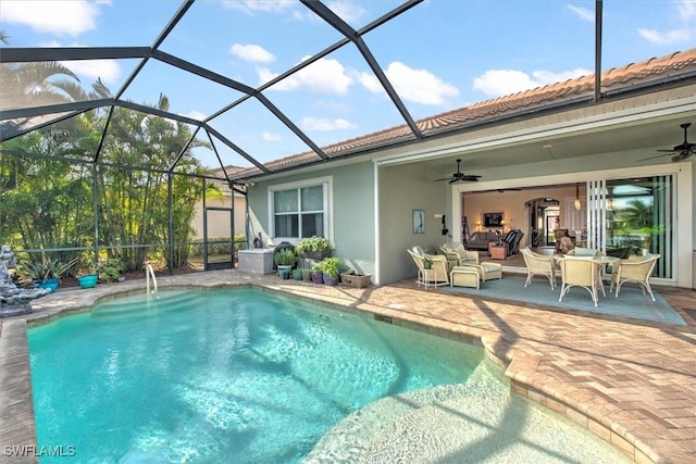 view of swimming pool featuring ceiling fan, glass enclosure, an outdoor hangout area, and a patio area