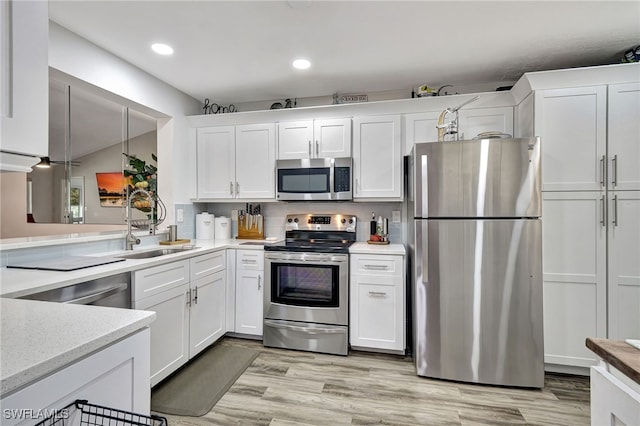 kitchen with white cabinetry, stainless steel appliances, sink, and pendant lighting