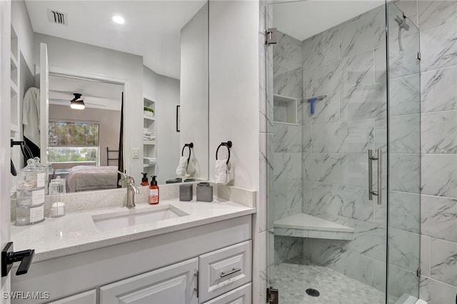 bathroom with walk in shower, ceiling fan, and vanity