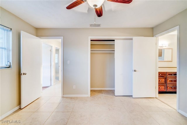 unfurnished bedroom with ceiling fan, light tile patterned floors, and a closet