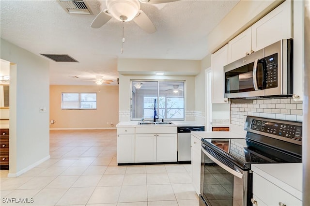 kitchen featuring sink, light tile patterned flooring, white cabinets, and stainless steel appliances