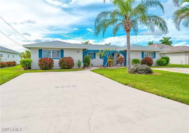 single story home with driveway, stucco siding, and a front yard