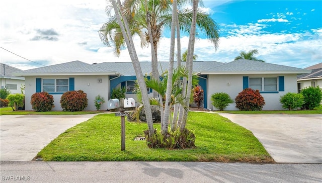 ranch-style house with driveway, a front lawn, and stucco siding