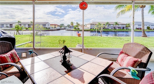 sunroom featuring a wealth of natural light and a water view