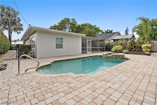 view of pool with a pool with connected hot tub, a patio area, and fence