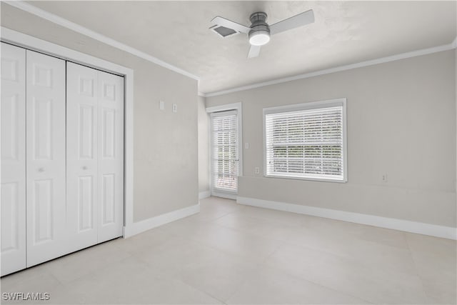 unfurnished bedroom with a closet, visible vents, ornamental molding, ceiling fan, and baseboards