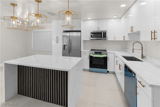 kitchen with light tile patterned floors, hanging light fixtures, stainless steel appliances, white cabinetry, and a sink