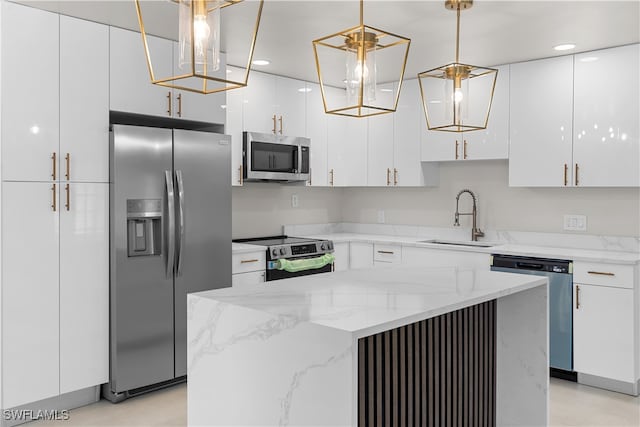 kitchen featuring light stone counters, stainless steel appliances, a sink, white cabinetry, and a center island