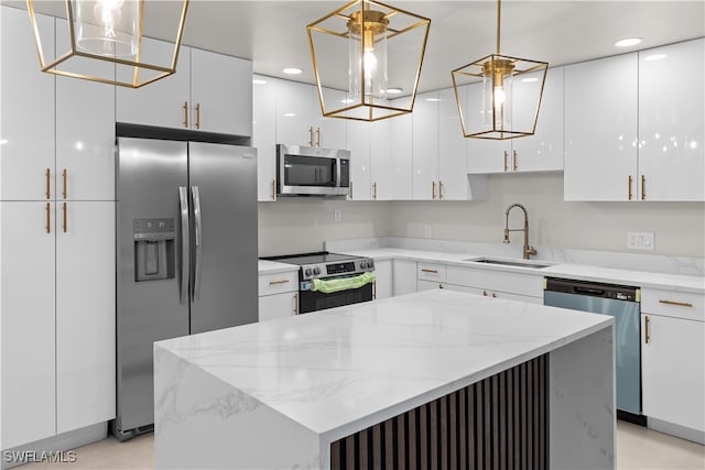 kitchen with appliances with stainless steel finishes, white cabinets, a sink, and a kitchen island