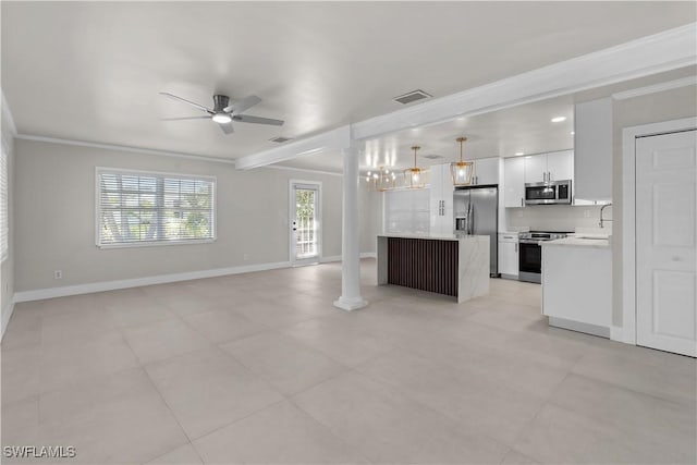 kitchen featuring white cabinets, open floor plan, stainless steel appliances, light countertops, and ornate columns