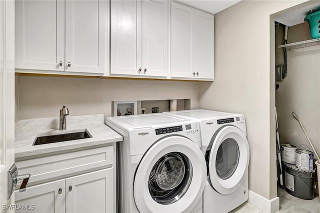 clothes washing area with cabinets, sink, and independent washer and dryer