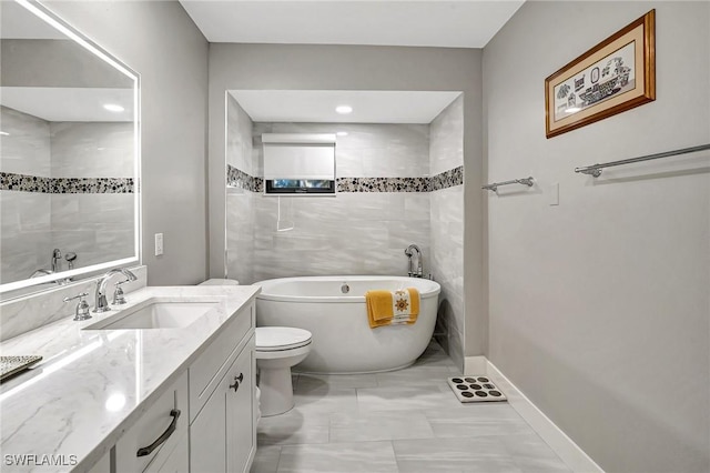 bathroom featuring vanity, toilet, and a tub to relax in