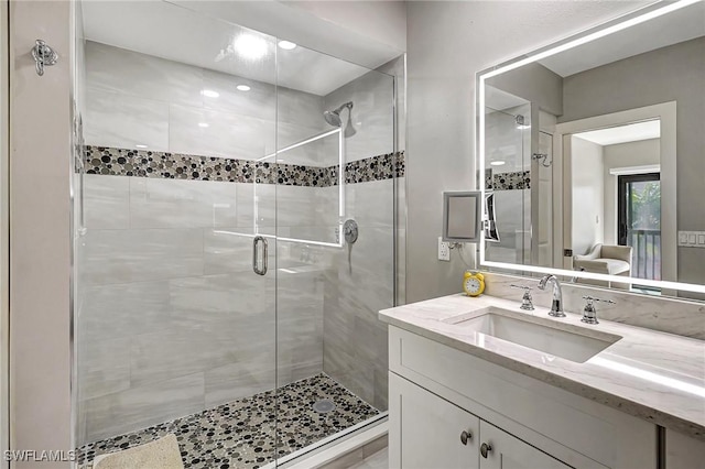 bathroom with vanity and a shower with door