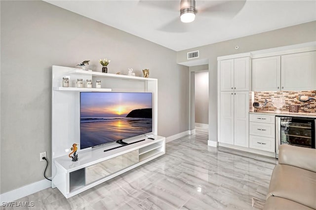 living room featuring beverage cooler, ceiling fan, and indoor bar