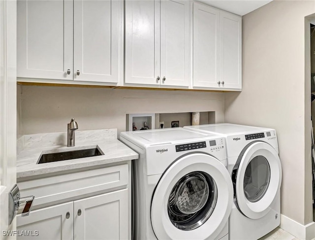 laundry area with washer and dryer, sink, and cabinets