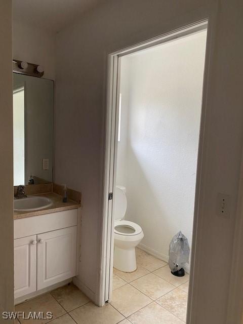 bathroom with toilet, tile patterned floors, and vanity