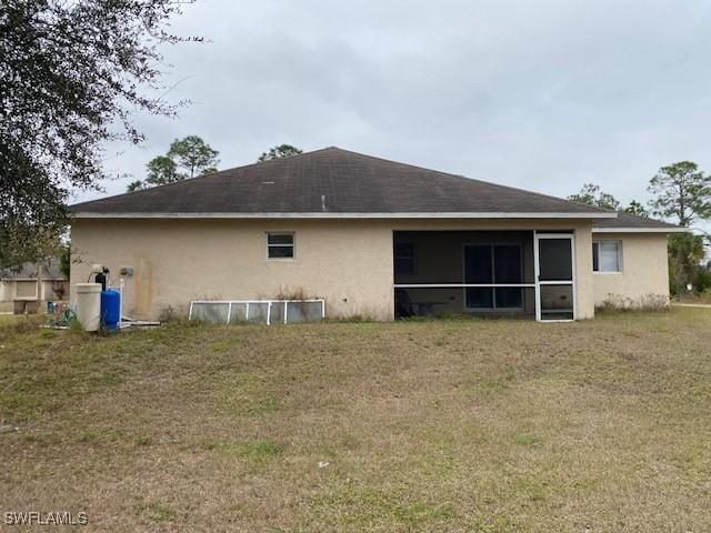 back of property featuring a yard and a sunroom