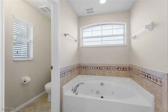 bathroom featuring a tub, tile patterned floors, and toilet