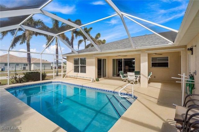 view of pool featuring a patio area, ceiling fan, and glass enclosure