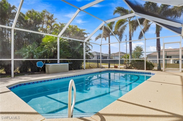 view of swimming pool featuring a patio and glass enclosure