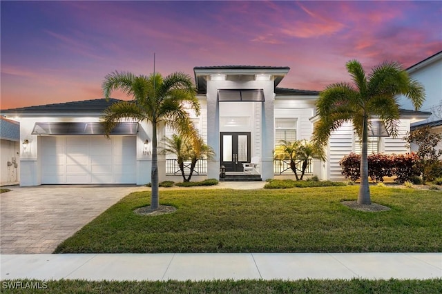 view of front of property featuring a lawn and a garage