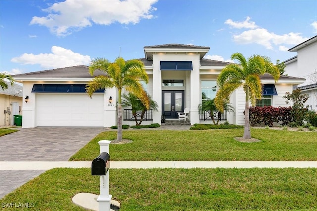 view of front of property with a garage, a front yard, and french doors