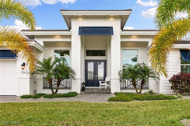 entrance to property featuring french doors and a yard