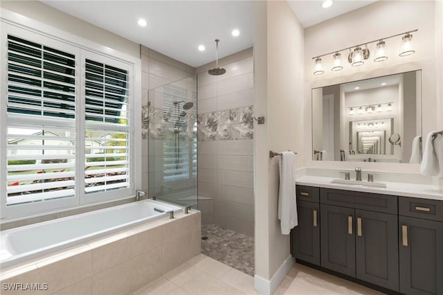 bathroom featuring plus walk in shower, tile patterned flooring, and vanity