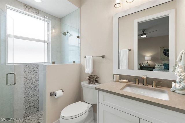 bathroom featuring a shower with door, toilet, and vanity