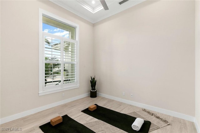 workout room featuring crown molding and light wood-type flooring