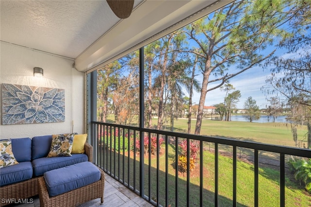 sunroom featuring a water view