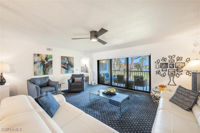 living room featuring a textured ceiling, ceiling fan, and carpet flooring