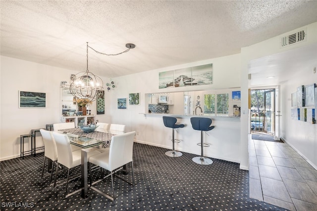 dining room with dark colored carpet and a textured ceiling