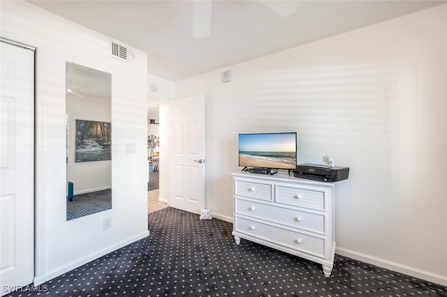 interior space featuring dark carpet and ceiling fan