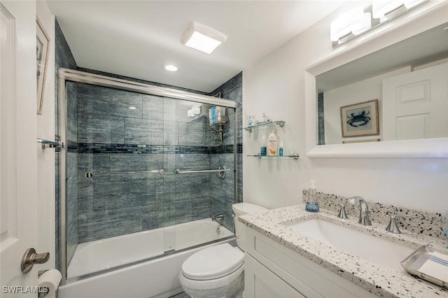 full bathroom featuring bath / shower combo with glass door, vanity, and toilet