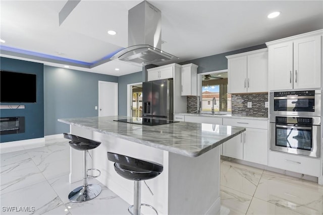 kitchen with refrigerator with ice dispenser, white cabinets, and island exhaust hood