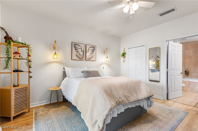 bedroom with ceiling fan, connected bathroom, light hardwood / wood-style floors, and a closet