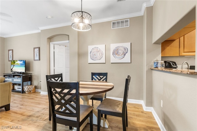 dining area featuring crown molding and light wood-type flooring