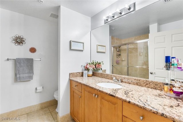 bathroom featuring vanity, tile patterned flooring, a shower with shower door, and toilet