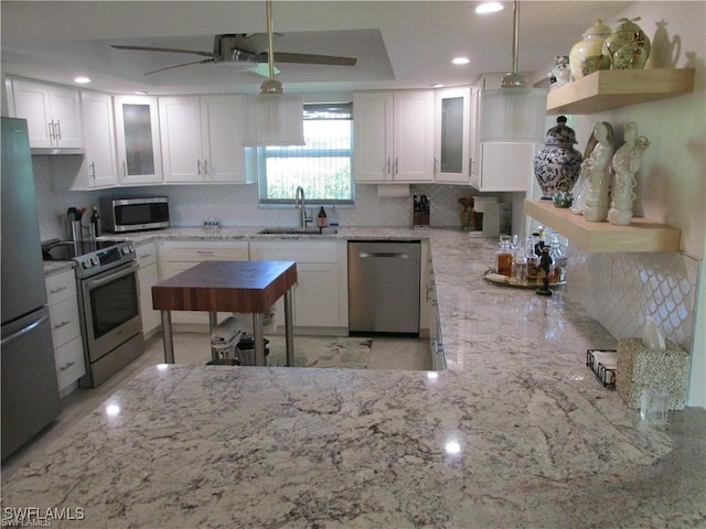 kitchen featuring sink, white cabinets, pendant lighting, and stainless steel appliances