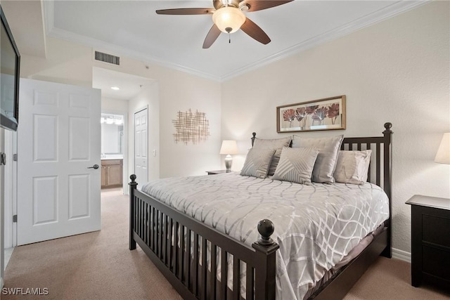 carpeted bedroom with ensuite bathroom, ornamental molding, ceiling fan, and a closet