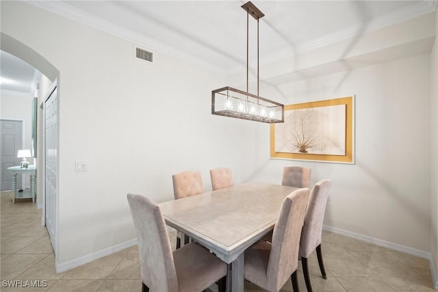 dining space with light tile patterned floors and crown molding