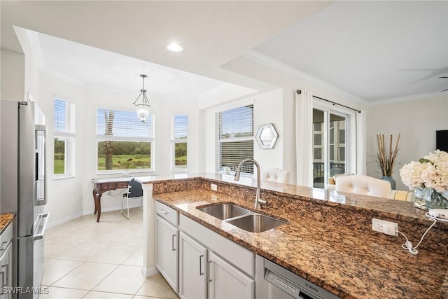 kitchen featuring sink, crown molding, hanging light fixtures, stainless steel appliances, and stone countertops