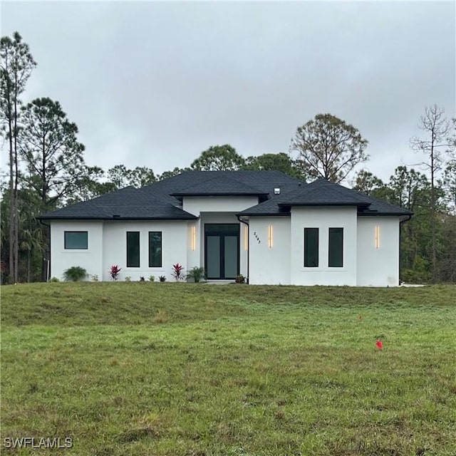 view of front of house with french doors and a front lawn