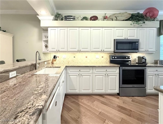 kitchen with white cabinetry, stainless steel appliances, crown molding, and sink