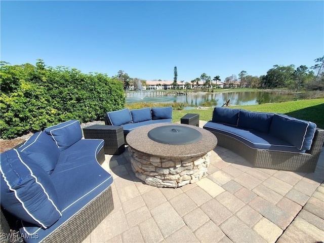 view of patio / terrace featuring an outdoor living space with a fire pit and a water view