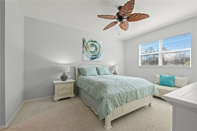 bedroom with ceiling fan, baseboards, and light carpet